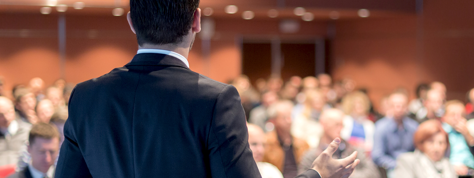 a man giving a presentation in front of a large crowd.