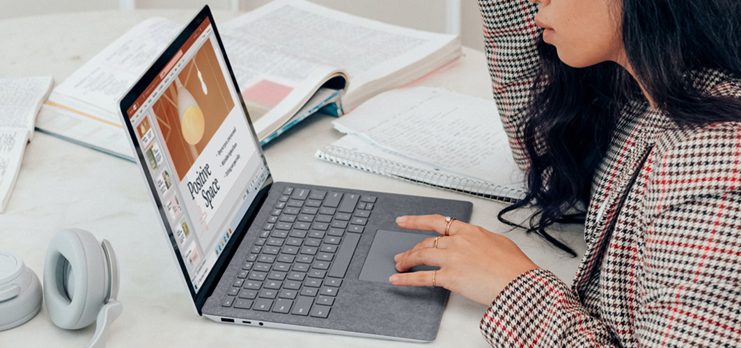 A side on view of someone using a laptop preparing a presentation.