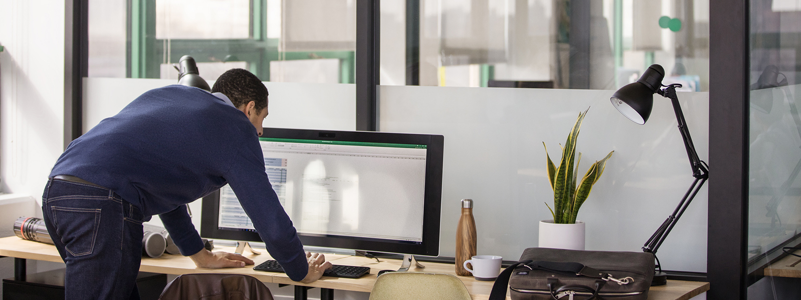 Someone leaning over a desk making the final adjustments to a spreadsheet.