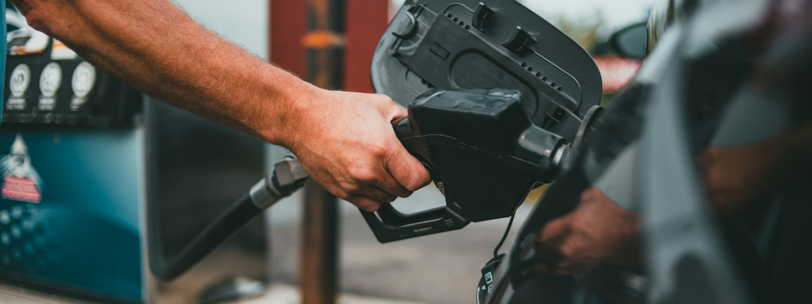 A hand pumping gas into their car