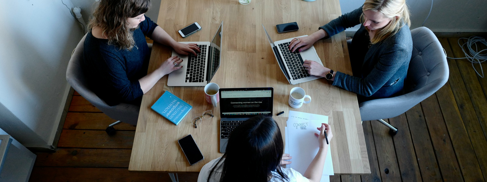 A group of women working on computers at a table