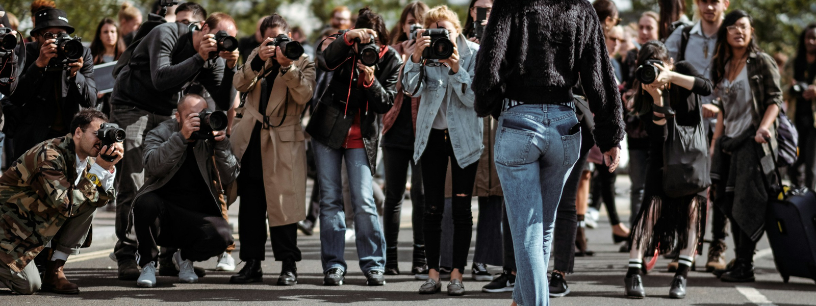 A group of photographers taking a picture of a woman