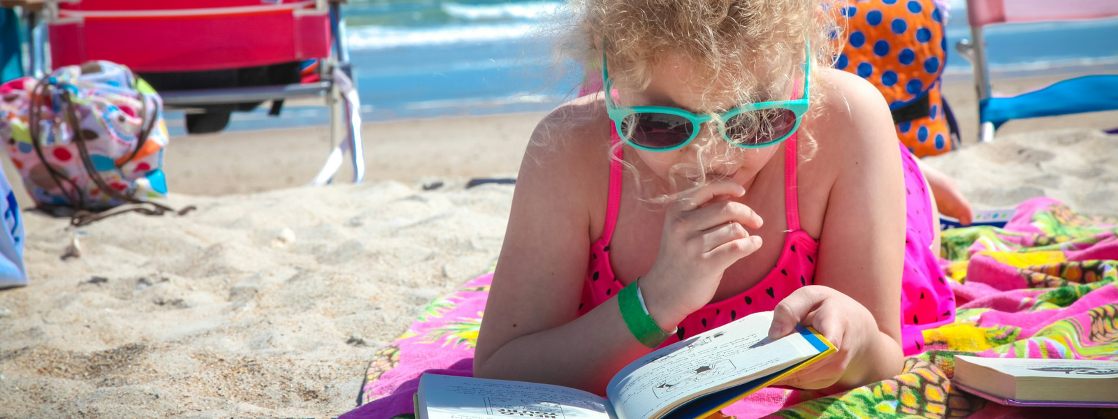 Girl reading a book on the beach