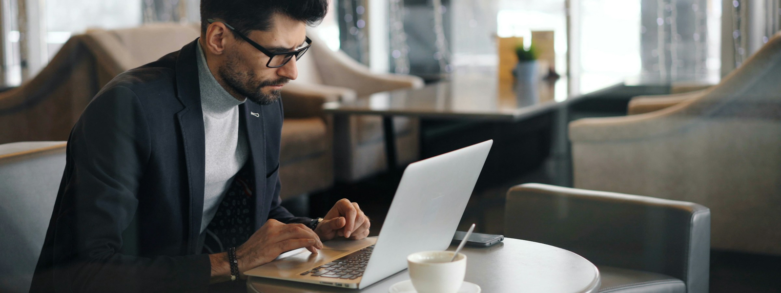 Man sitting at a table using his laptop