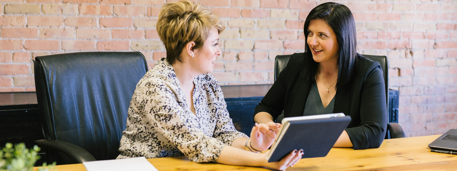 Two women chatting during a meeting