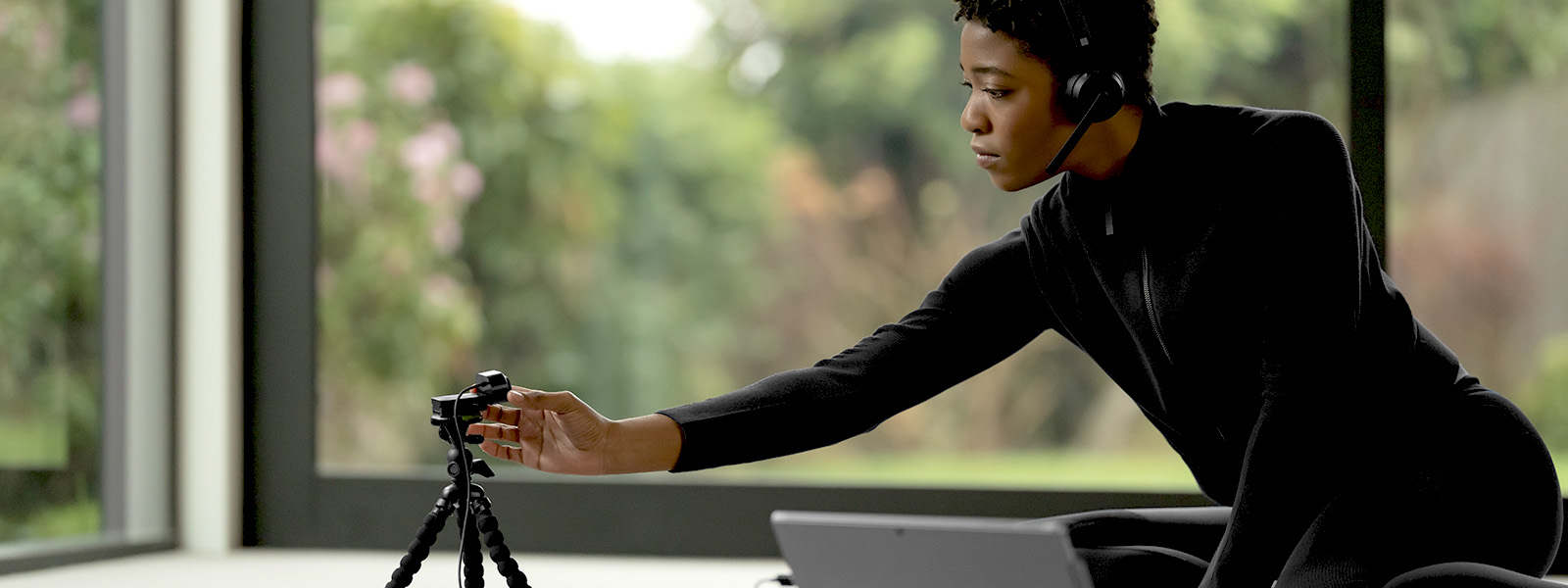 a person wearing a headset setting up a webcam.