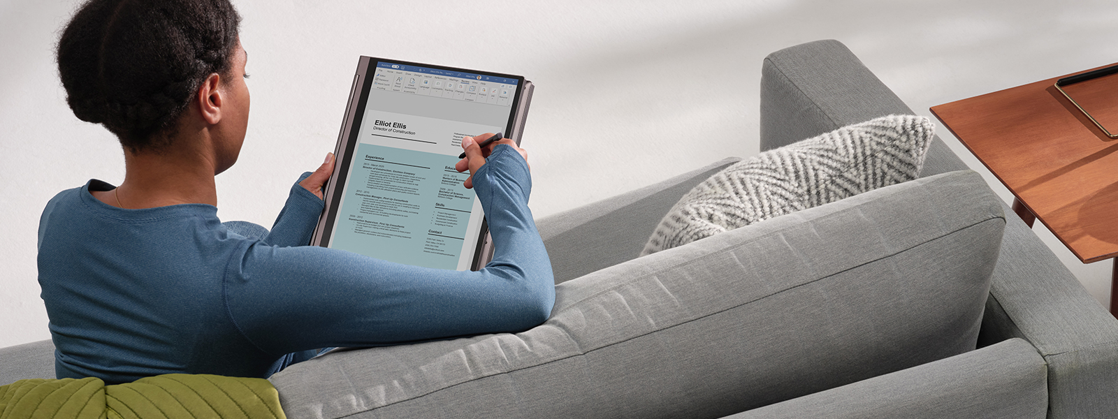 Woman using a digital pen inking to review a resume Word document using HP Spectre X360