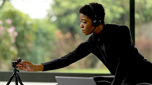 a person wearing a headset setting up a webcam