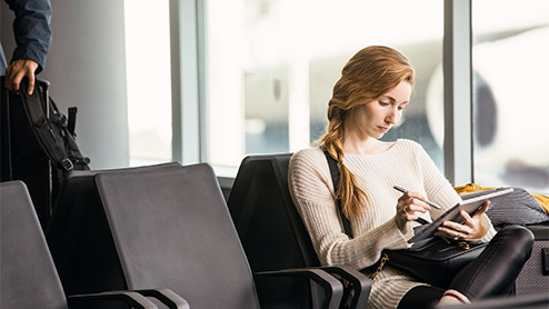 Enterprise young female achieving in airport during business travel and mobility. Including Surface Pen.