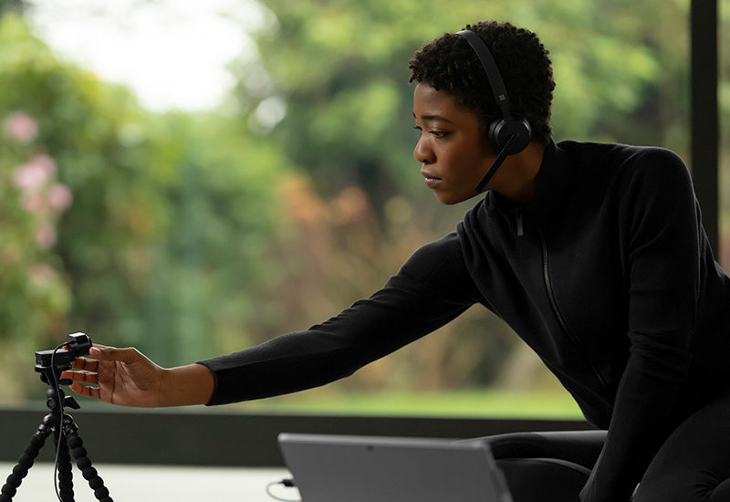 a person wearing a headset setting up a webcam